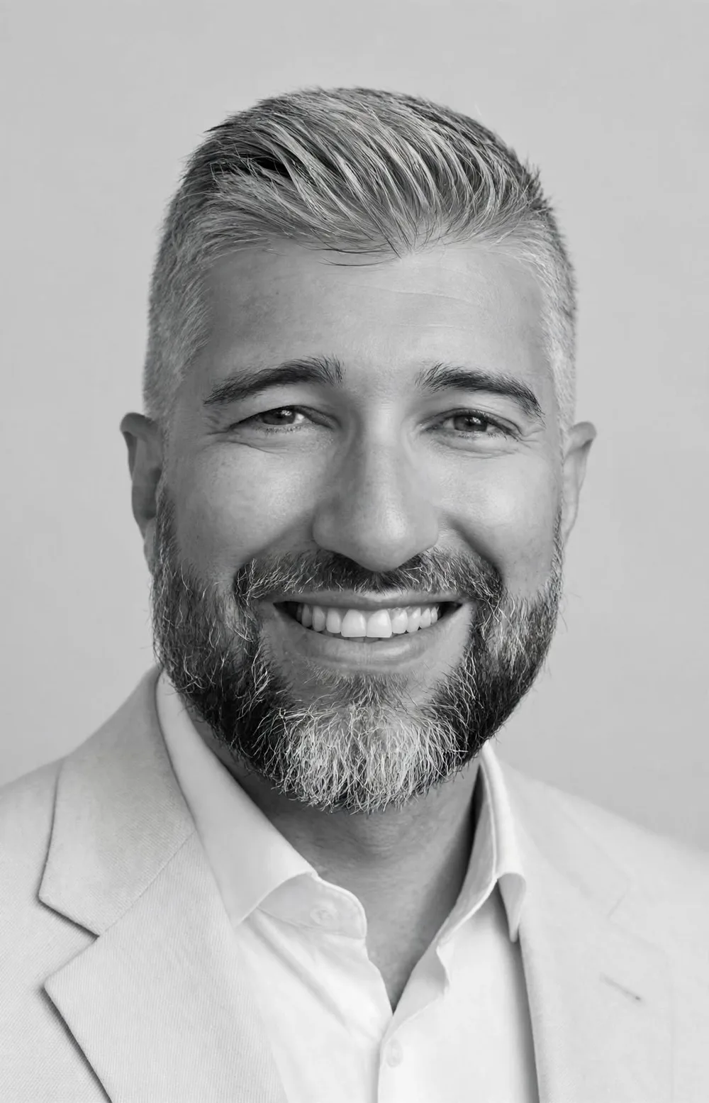 Portrait de Jérémy Darnis, souriant, en veste claire et chemise blanche.